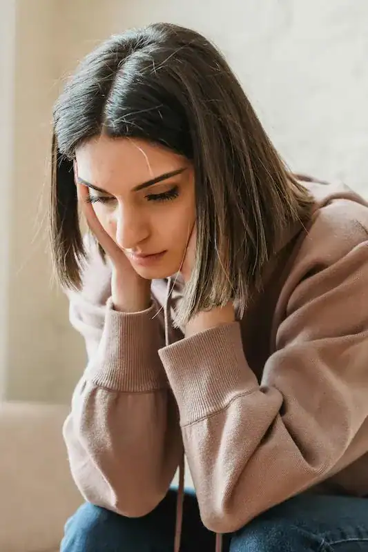 woman sitting with head resting in hands