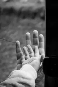 Parent and child holding hands, symbolizing support and connection while talking about autism.