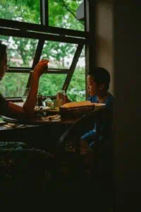 Parent and child sitting together on a couch, talking warmly about autism in a supportive way.