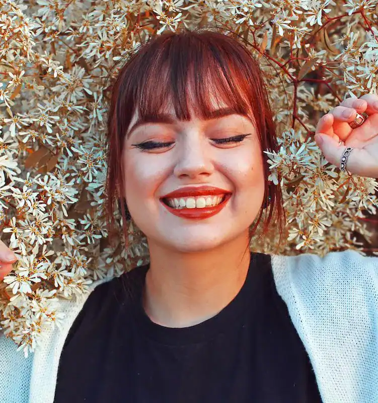 woman laying in flowers smiling