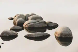leo_visions-YdmQa9PqEFY-unsplash | Catalyst Center Stones on a riverbank, symbolizing coexistence of challenge and celebration in autism