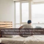 Why Men Avoid Seeking Help for Sexual Problems The Hidden Influence of Masculinity Norms | Catalyst Center Man sitting on bed looking contemplative about seeking help for erectile dysfunction.
