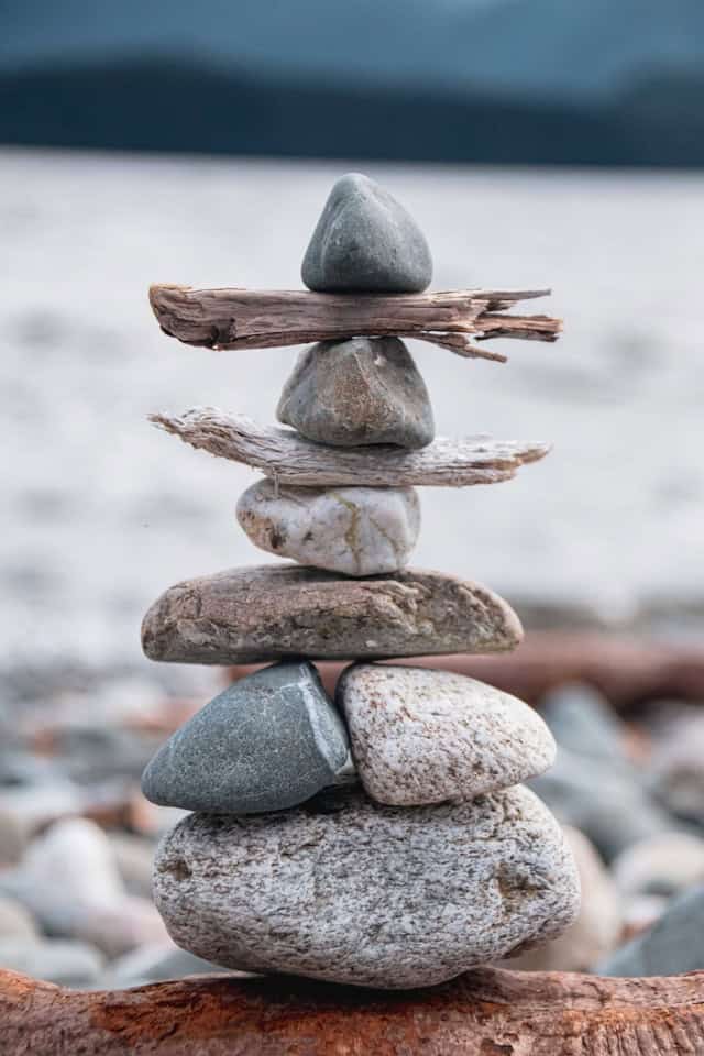 Smooth stones balanced in a stack, symbolizing grounding, regulation, and steady Self-leadership built one part at a time